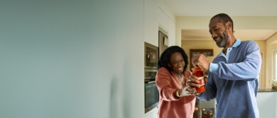 Elderly couple opening a jar of pasta sauce